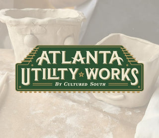 Atlanta Utility Works logo on a textured surface with a blurred background