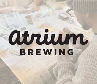 Person sitting at a table with 'Atrium Brewing' logo overlay