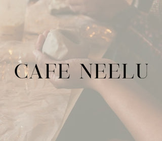 Text 'CAFE NEELU' over a blurred background with soft lighting