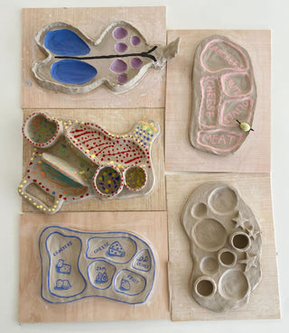 Collection of ceramic charuterie boards on a wooden surface