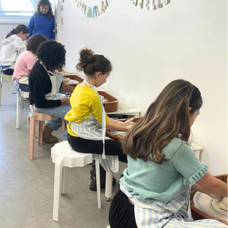 Kids working with clay on a pottery wheel and a classroom setting with students in pottery class.