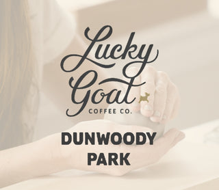 Lucky Goat Coffee Co. Dunwoody Park logo on a blurred background of someone forming a pinch pot