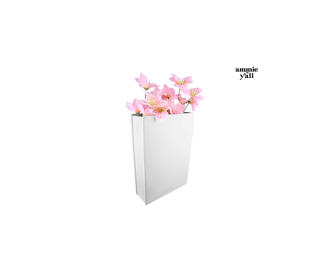 A white rectangular vase or planter holding pink artificial flowers, shown on a plain white background with small black text reading 'amnie y'all' near the upper right.