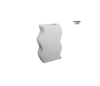 A white ceramic planter with a wavy, organic silhouette and a rectangular opening at the top, shown against a plain white background with the text 'amnie y'all' in the upper right.