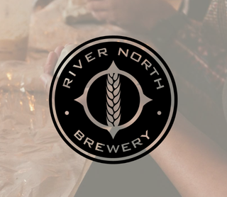 A circular black and white logo for River North Brewery is centered over a softly blurred background showing a person holding a glass of beer.