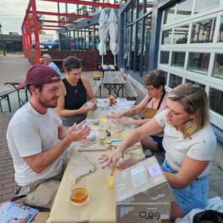 Group of people working on a project outdoors with materials and tools.