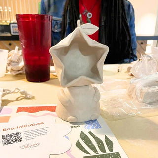 Star-shaped ceramic object on a table with a red cup and person in the background
