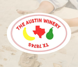 Round sticker with 'The Austin Winery' branding featuring a map of Texas, bananas, and a pear on a blurred background.