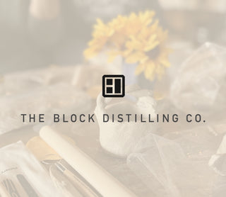 The Block Distilling Co. logo with pottwery and flowers in the background