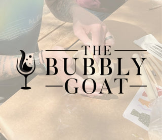 Logo of 'The Bubbly Goat' with a blurred background of people and pottery.