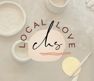 A styled flat-lay of pottery tools and clay on a light surface, with a central logo reading 'LOCAL LOVE chs' over a peach circle.