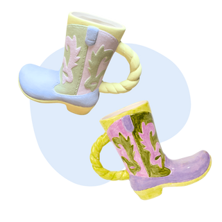 Two cowboy boot-shaped mugs with colorful designs on a blue background