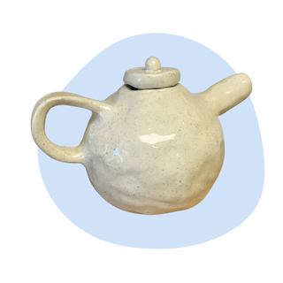 Ceramic teapot with a lid on a light blue background