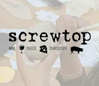 A person's hands holding a ceramic object over a wooden workbench with sketches and tools, overlaid with the text 'screwtop' and smaller words 'WINE', 'CHEESE', and 'CHARCUTERIE' with small icons.